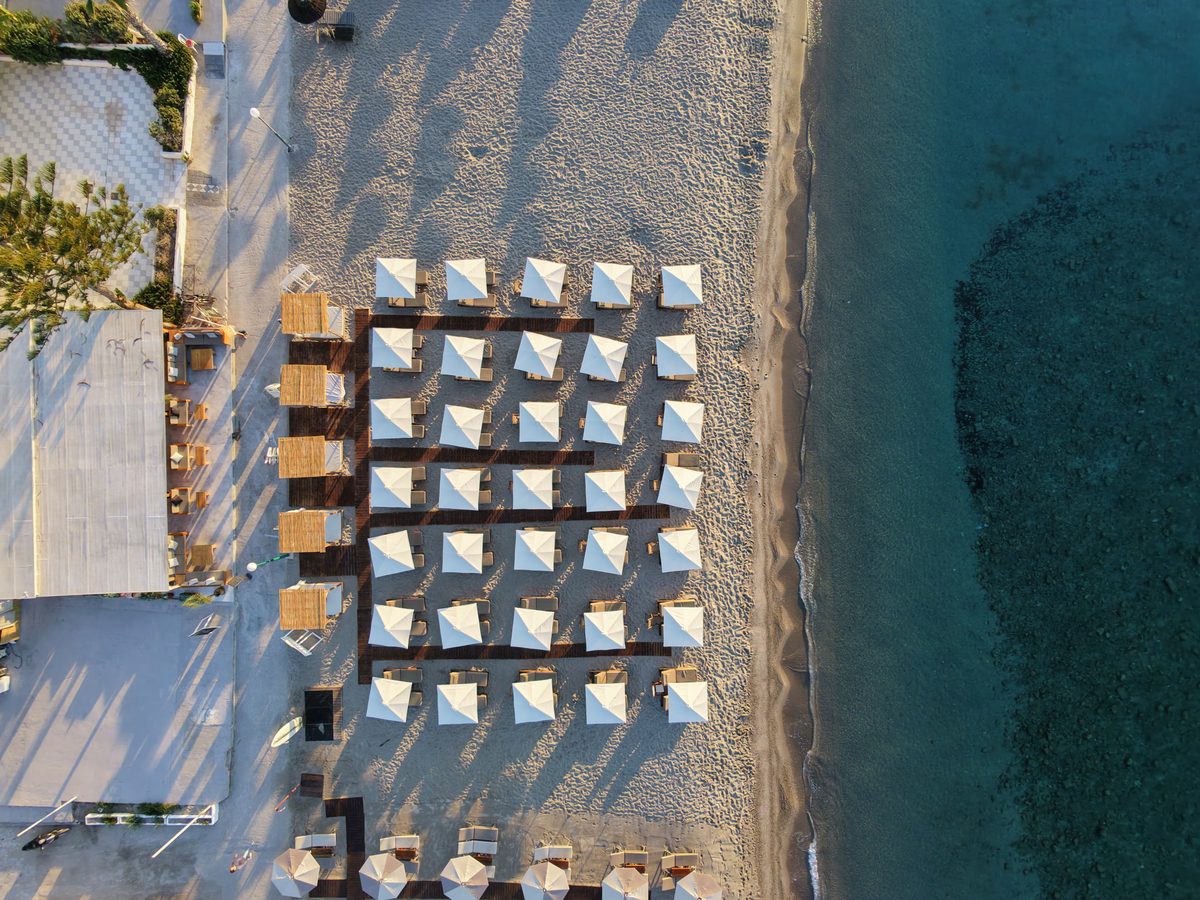 Rows of sunbeds and parasols on the beach at Starlight seen from above