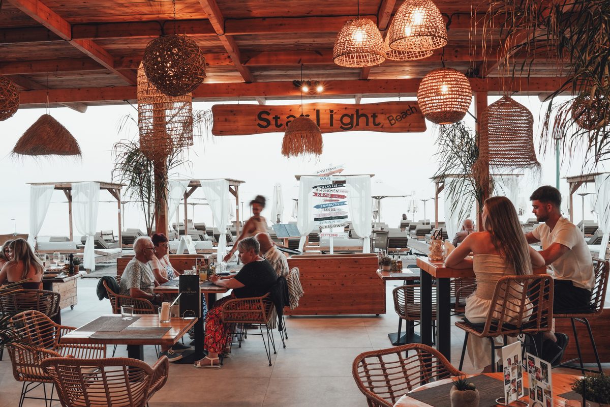 Tables and loungers at Starlight Beach Bar with the Aegean Sea behind