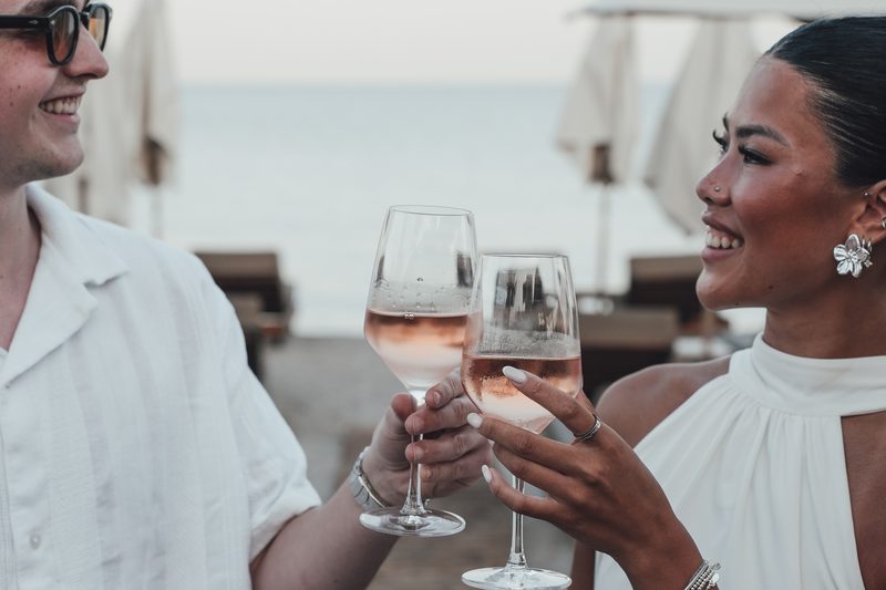Two glasses of wine raised at sunset at Starlight Beach Bar