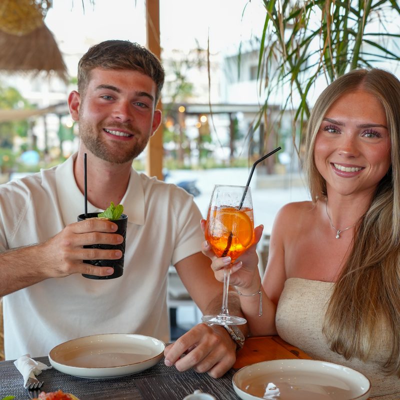 Aperol spritz held against the sea