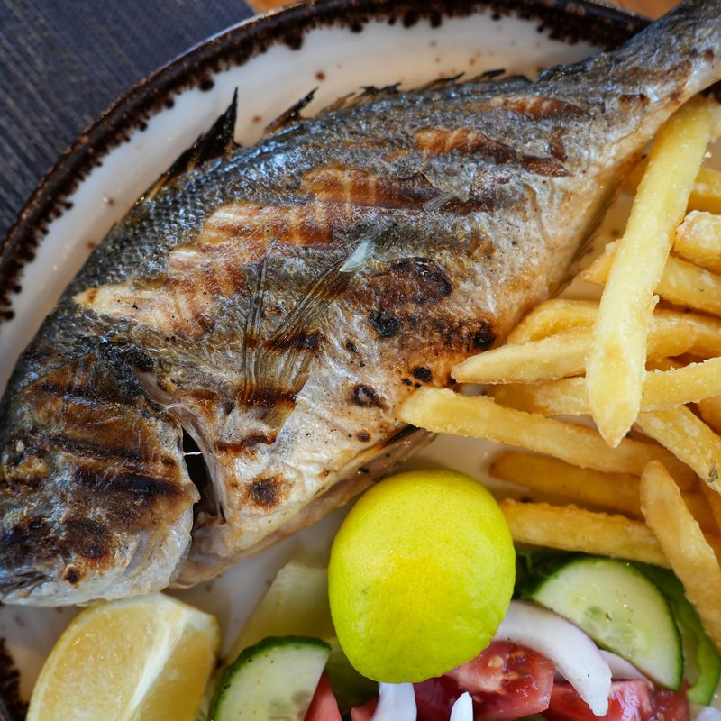 Whole grilled fish of the day served with fries and salad at Starlight Kitchen