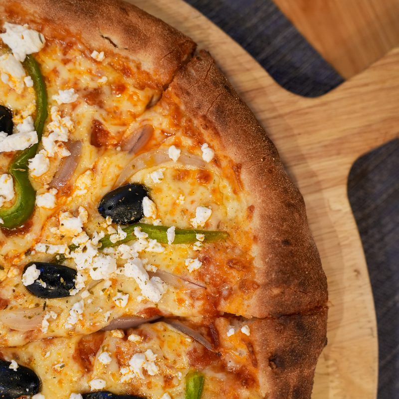 Stone-baked pizza with feta, olives and peppers at Starlight Kitchen
