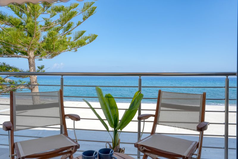 Private sea-view balcony of the Deluxe room with two chairs and a table