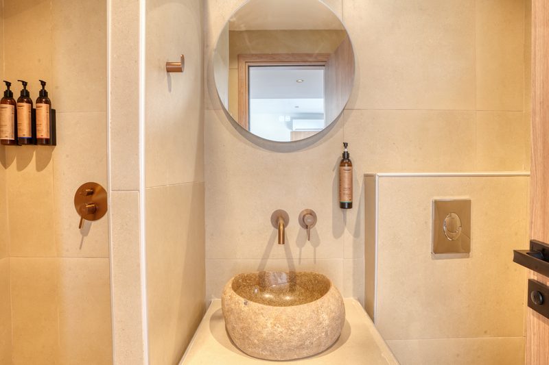 Modern bathroom with stone basin and walk-in shower in the Deluxe room