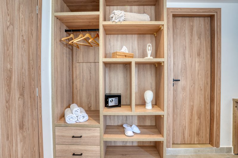 Open wardrobe with shelving, towels and safety deposit box in the Deluxe room