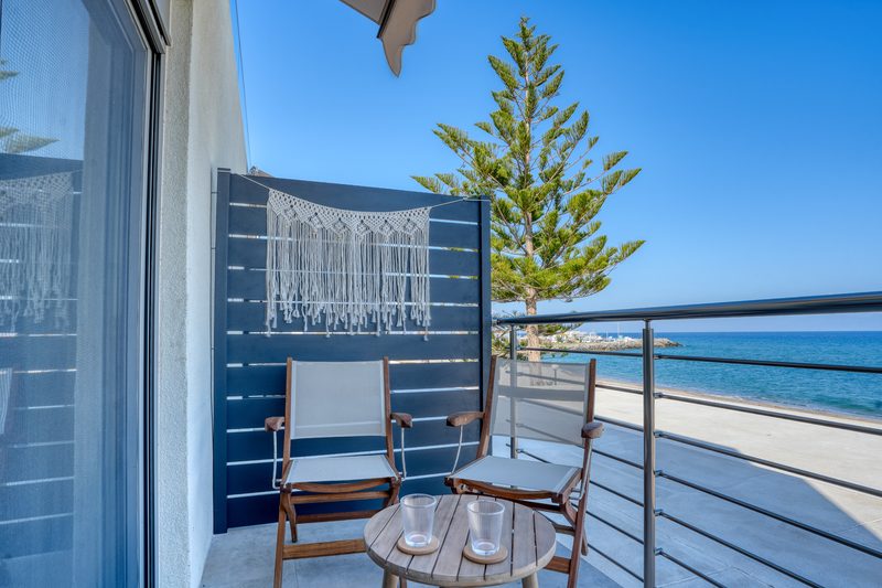Balcony of the Superior room with table, chairs and a view of the beach