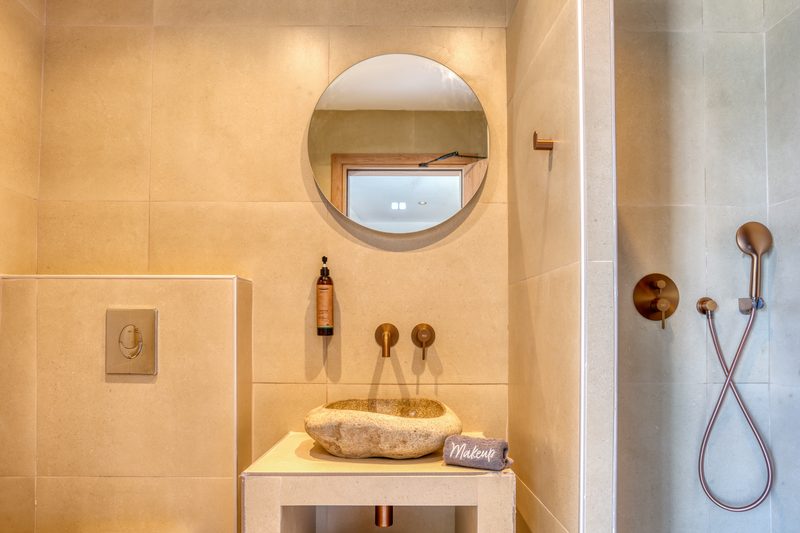 Bathroom of the Superior room with round mirror and brushed brass fittings