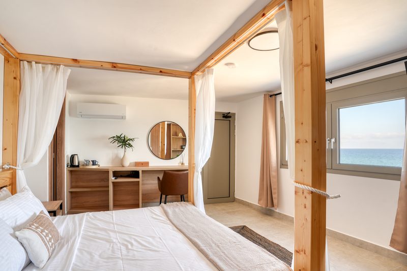 Interior of the Penthouse showing the four-poster bed, desk and sea view