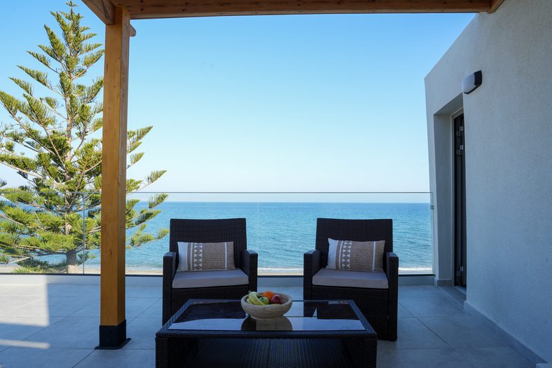 Large private terrace of the Penthouse with lounge chairs facing the sea